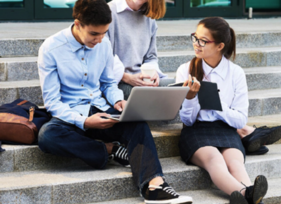 Schüler sitzen auf Treppe mit Laptop