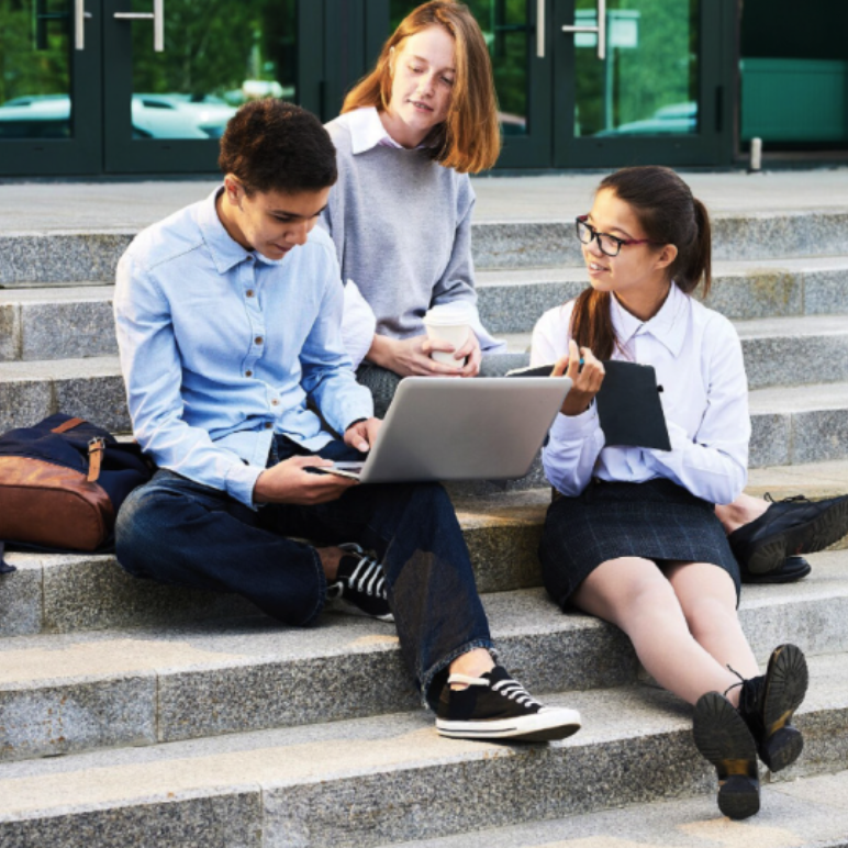Schüler sitzen auf Treppe mit Laptop