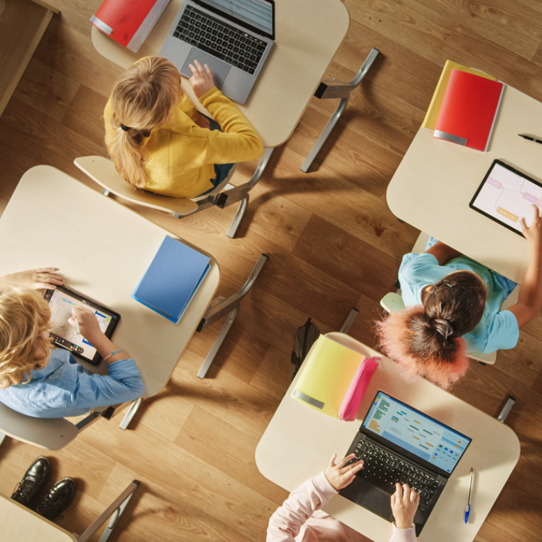 Schüler in Klasse am Tisch mit Computern